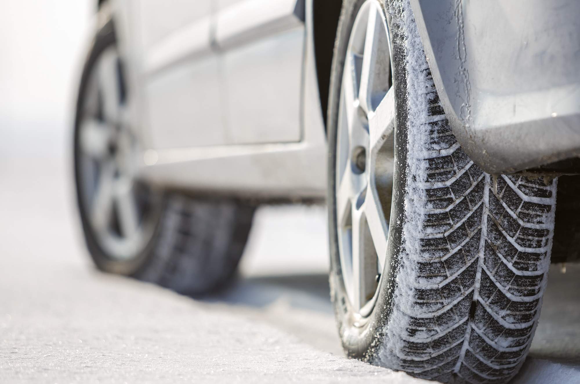 Close-up of car wheels rubber tire in deep snow. Transportation and safety concept.